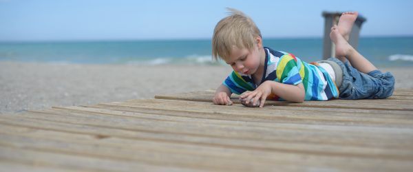 Child on a costal trip playing on the beach